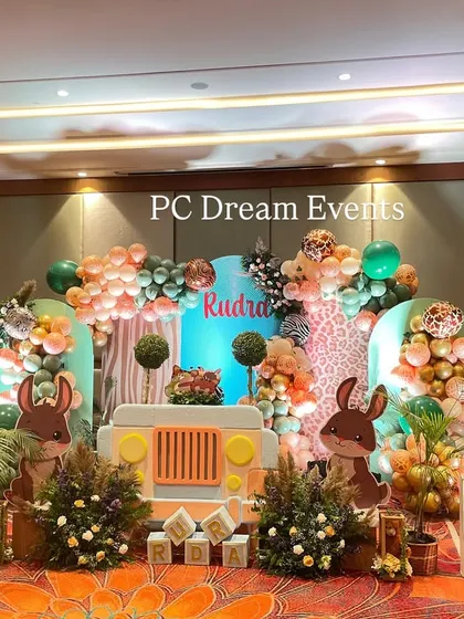 We brought the jungle to life for Rudra's first birthday with this large-scale safari theme decoration. The setup features a custom backdrop with a jeep cutout, friendly animal characters, and organic balloon garlands in a jungle-inspired color palette.