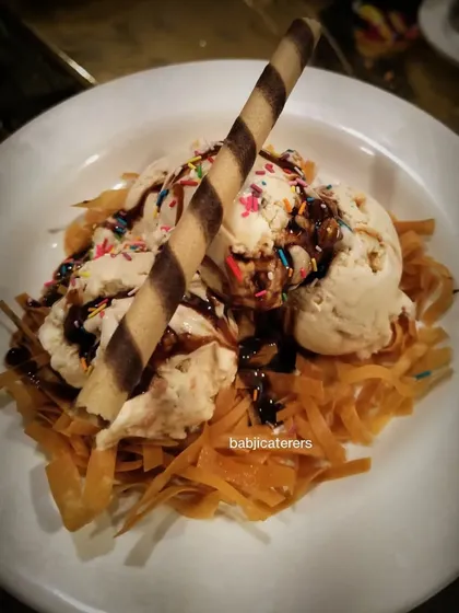 A creative dessert: Honey Nut Ice Cream served over a bed of crispy fried noodles. It's a fusion dessert that combines sweet, savory, and crunchy elements.