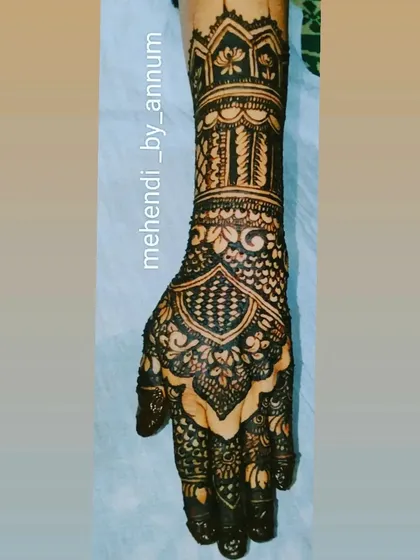 This full-hand design features architectural-inspired patterns on the wrist, blending into floral and jaal work on the palm. It's a modern take on classic bridal henna.