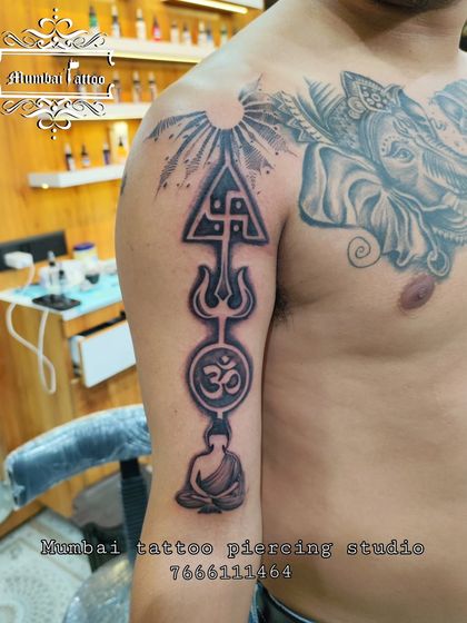 A large spiritual tattoo sleeve in progress, combining a meditating Buddha, the Om symbol, a Trishul, and a Swastika. This piece is a powerful amalgamation of different spiritual paths.
