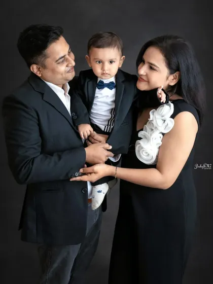 A loving family moment. The parents look at each other while holding their adorable son, creating a beautiful and connected family portrait.