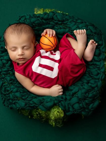 A perfect overhead shot of the basketball theme, capturing the vibrant colors and the adorable, sporty setup. These themed shoots are a great way to incorporate parents' hobbies.