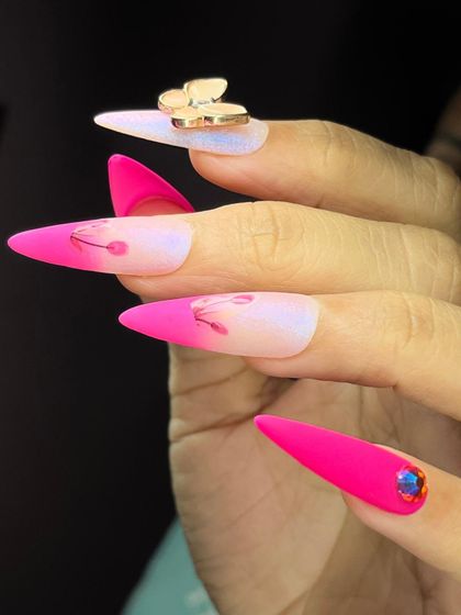A striking design combining a soft ombre base with a bold, matte hot pink tip and a delicate gold butterfly charm.