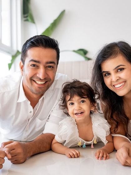 A happy family of three, smiling for the camera during their studio session.