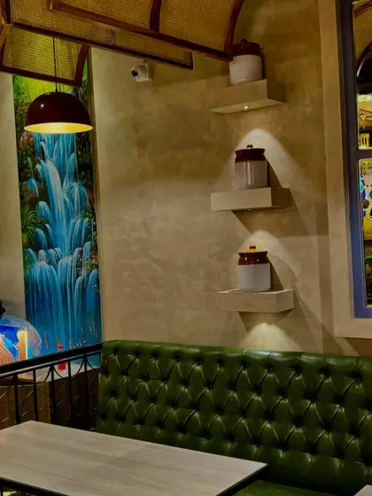 Our decor features unique touches like this waterfall mural and traditional pickle jars, bringing a piece of Punjab to your table.