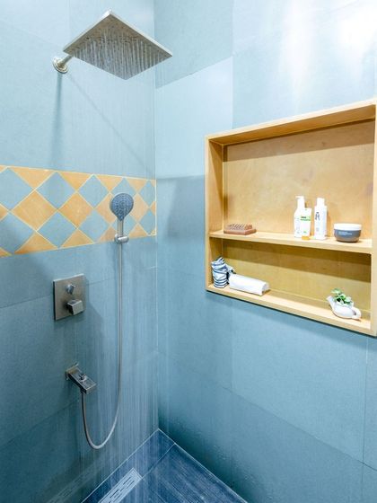 The water flowing in the shower highlights the texture and color of the Kota stone.