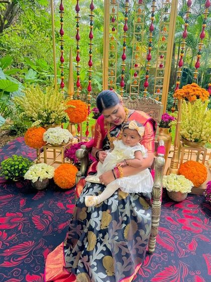 A heartwarming moment between Pavithra and a baby, showcasing the saree's suitability for family functions.