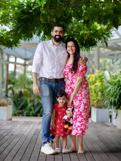 A picture perfect family portrait taken on a beautiful wooden boardwalk surrounded by lush plants. Outdoor settings provide such a vibrant backdrop for family photos.