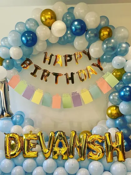 A close-up of the balloon arch, showing the mix of light blue, white, and chrome gold balloons.