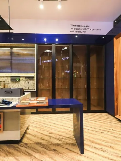This shot showcases the variety of finishes available, from the deep blue PU to the natural wood folding doors and glass display cabinets.