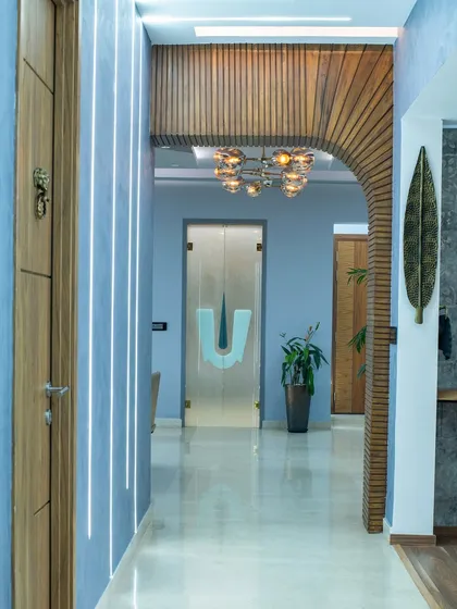 This corridor at SNN Clermont is defined by light, symmetry, and linear patterns. The teak-finished wooden archway guides you through the space, creating a stunning visual journey.