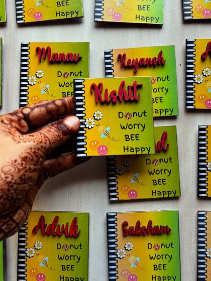Looking for unique return favors? Our customized handmade fridge magnets make the perfect keepsake. This image shows a bulk order of personalized "Donut worry, BEE happy" magnets.