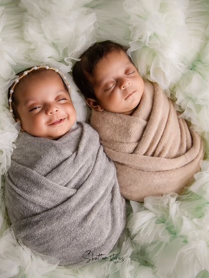 A joyful twin portrait, capturing a beautiful smile. Posing twins together on a soft, textured background creates a feeling of connection.