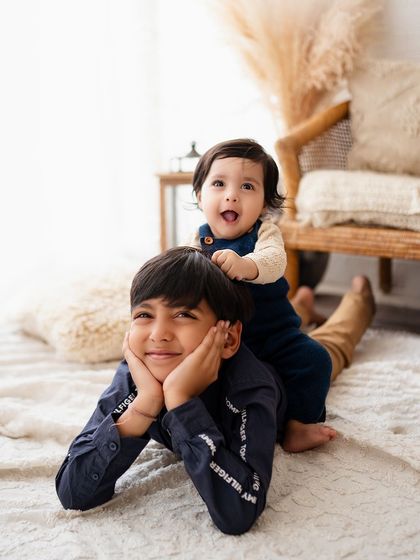 The best kind of playground! This playful shot of a baby riding on his big brother's back is full of laughter and sibling love.