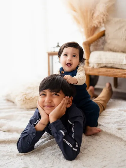 The best kind of playground! This playful shot of a baby riding on his big brother's back is full of laughter and sibling love.
