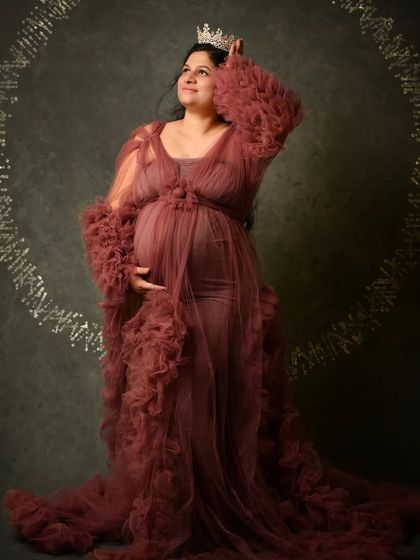 A full-length portrait featuring a beautiful crown and a DNA-inspired circular prop, symbolizing the creation of new life.