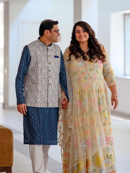 A slightly different angle of the couple walking hand-in-hand, capturing their loving glances and the beautiful indoor lighting.