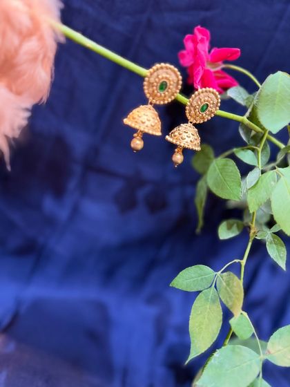 Another view of the beautiful gold and green jhumkas, showcasing their intricate design. A must-have in every woman's jewellery collection.