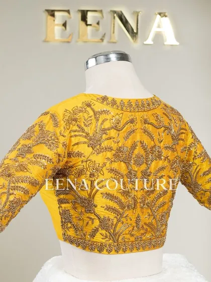 This sunshine yellow raw silk blouse is brought to life with meticulous hand embroidery by my talented artisans. The dense, traditional motifs in antique gold threadwork cover the back and sleeves, creating a piece that radiates warmth and luxury.