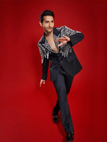 I handcrafted this debonair black suit for Arjun Tanwar's HELLO! Magazine digital cover. The design features classic broad lapels, but the shoulders and pockets are adorned with dazzling stones and beaded tassels for a touch of dramatic flair.