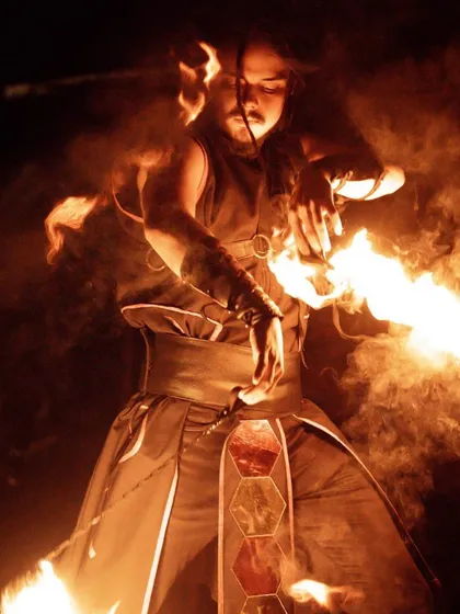 The intensity of a fire poi artist, captured in a moment of deep concentration. This image showcases the close connection between the performer and their instrument, a core element of the tech poi style we practice and teach.