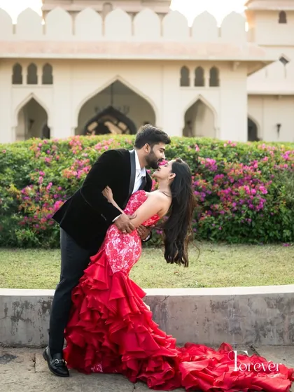 Creating outfits that move with you and tell a story of romance. This dramatic red ruffled gown, with its lace bodice and voluminous skirt, was designed for a cinematic pre wedding shoot, capturing a moment of pure joy.