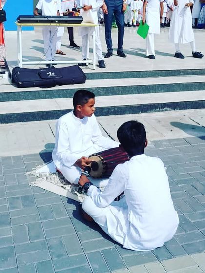 Young students playing traditional Indian percussion instruments as part of their school's Independence Day celebration performance.