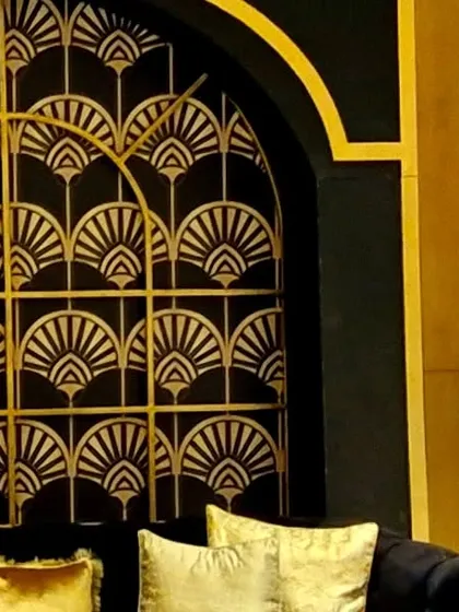 A close-up of the Art Deco paneling, showing the clean lines and metallic finish that catch the light beautifully. These custom structures are a core part of how we build a unique world for your event.