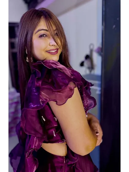 Vintage flair for the modern era. This look in a deep purple outfit has a touch of retro charm with a modern, glamorous twist.