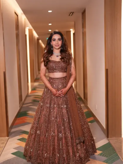 A full-length view of this gorgeous bride's reception look. We chose a contemporary brown sequined lehenga that was both glamorous and comfortable, allowing her to move and celebrate freely. The diamond necklace adds the perfect touch of sparkle.