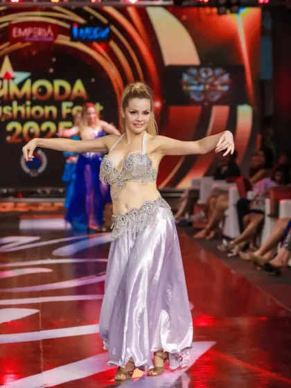 Another angle of the dancer in the silver costume, showcasing her elegant posture and the energy of the performance.