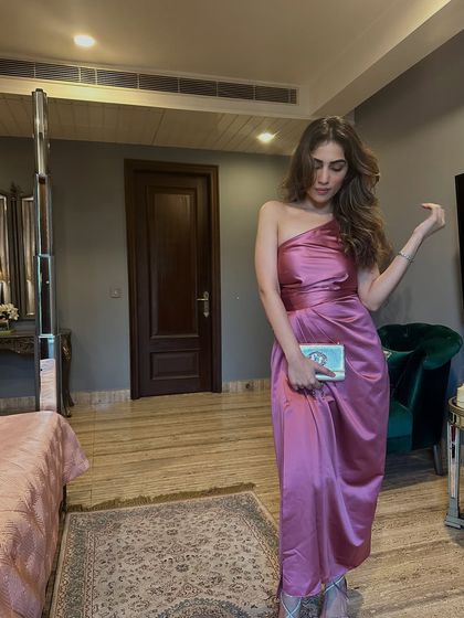 A beautiful one-shoulder satin dress in a dusty pink shade. This is a perfect dress for a cocktail party or a wedding guest look.