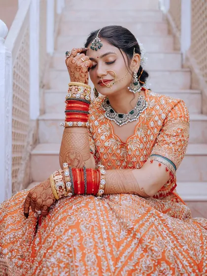 A beautiful candid shot of the bride, highlighting her henna-adorned hands and stunning jewelry.