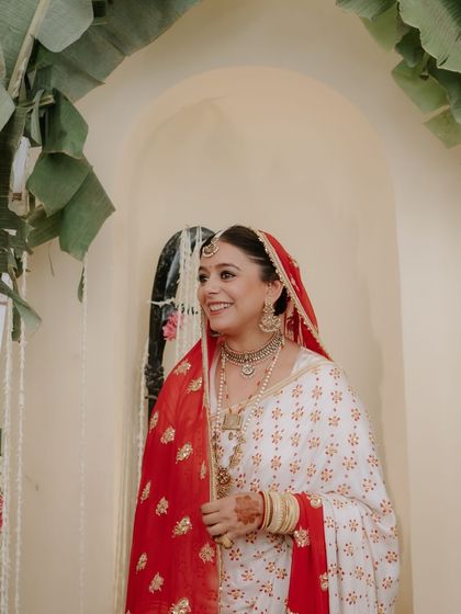 A series of portraits of a bride in a beautiful, traditional white and red saree, capturing her elegance, emotion, and moments with her family.