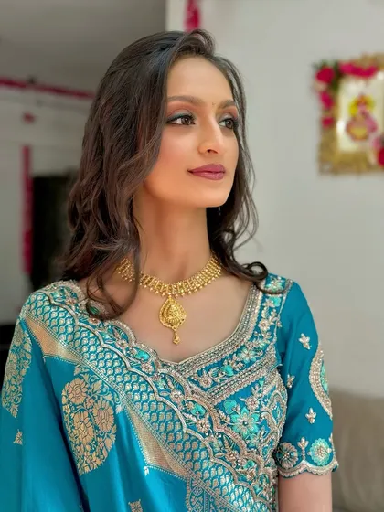 A close-up of the makeup, showing the warm tones on her eyes and the flawless skin.