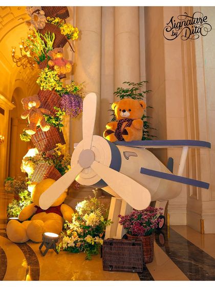 A large vintage airplane prop with a teddy bear pilot, part of the whimsical decor for the London-themed first birthday.
