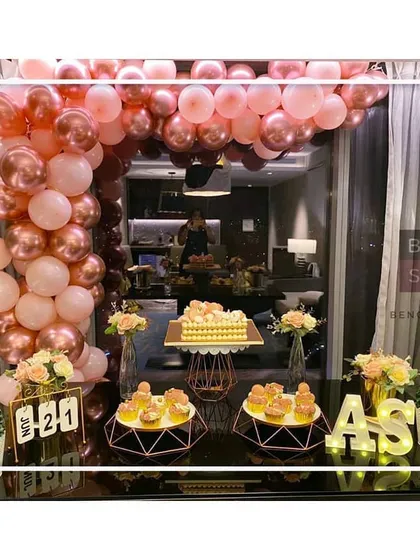 We love celebrating love, and this first-anniversary setup was all about modern romance. We designed a stunning rose gold and pink balloon arch over a dessert table, complete with custom initial marquee lights and geometric stands for a truly stylish and personalized event.