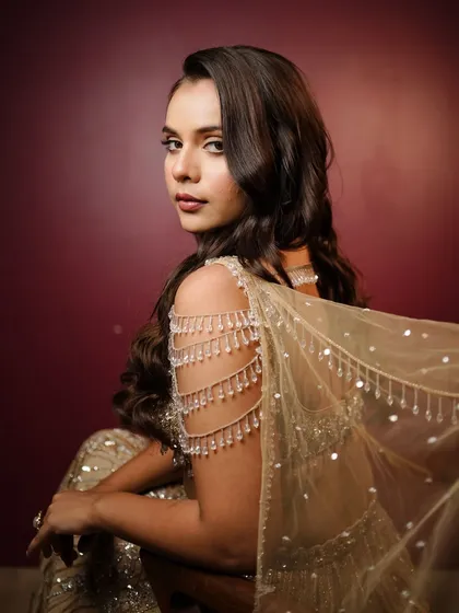 The way the light catches the details on her outfit and the glow on her skin is just magical. This is a perfect reception look for the modern bride.