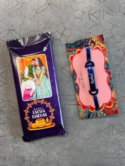 Sweet and personal, this Rakhi combo includes a custom photo chocolate bar and a personalized name bracelet, available in three colors.
