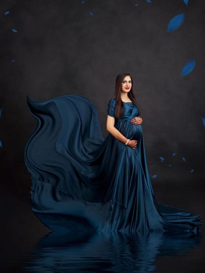 A creative edit with a water reflection and falling blue leaves, adding a touch of magic to this elegant teal gown portrait.