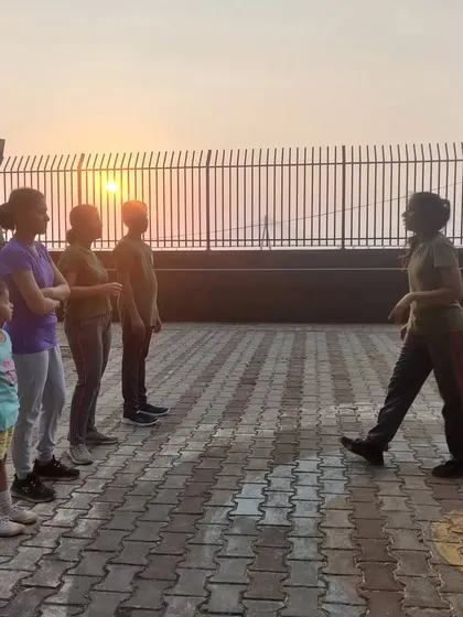 An instructor leads the group in pre-practice exercises against a beautiful sunset. We train the body and the mind.