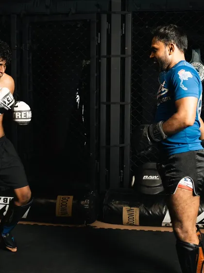Two fighters face off during a sparring session, assessing distance and timing before engaging.