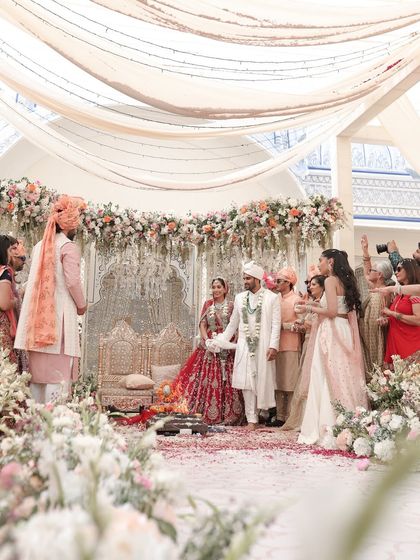 A full view of the pheras ceremony in progress. The floral-lined aisle, the elegant mandap, and the gathering of family and friends all come together to create a picture of pure joy and tradition.