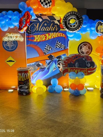 Another angle of the Hot Wheels stage, showing the custom props, marquee number, and full balloon arch.