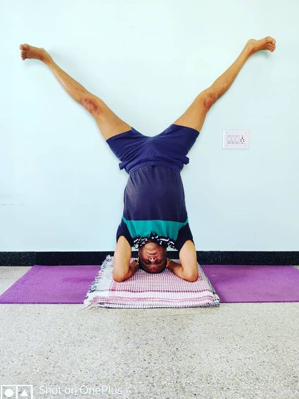 Upavistha Konasana in Shirshasana (Wide-Angle Seated Pose in Headstand). This variation challenges your balance and core control while in an inversion.