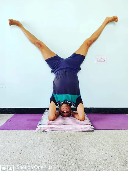 Upavistha Konasana in Shirshasana (Wide-Angle Seated Pose in Headstand). This variation challenges your balance and core control while in an inversion.