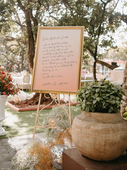 The welcome signage was designed to feel like a personal, handwritten note from the couple, set on an ombré coral background.