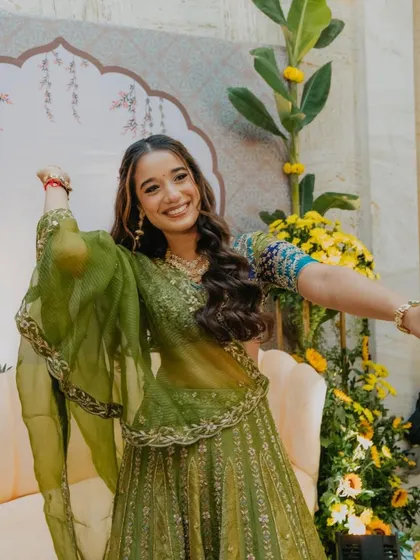 A happy, dancing bride at her mehendi, looking vibrant and full of life.