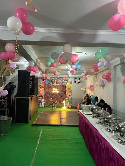 This image shows the full party layout, including the Cocomelon backdrop, dance floor, and buffet area.