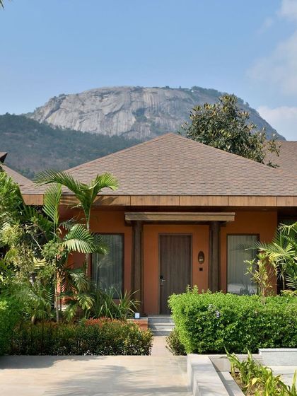 An exterior view of our award-winning boutique bungalows, showcasing the harmony between our architecture and the stunning natural landscape of Nandi Hills.